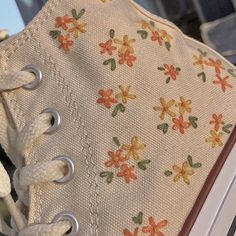 a pair of white shoes with flowers on them are sitting on top of an open book