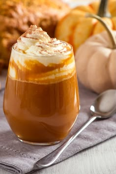 a glass filled with liquid sitting on top of a table next to bread and cinnamon sticks