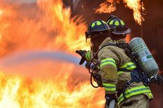 a firefighter is using a hose to extinguish the flames