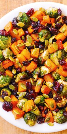 a white plate topped with brussel sprouts and sweet potatoes