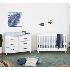 a baby's room with a crib and dresser