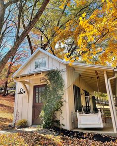 a small white shed sitting next to a tree