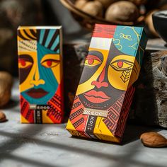 two colorful boxes sitting on top of a table filled with nuts and nutshells