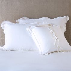 three white pillows sitting on top of a bed