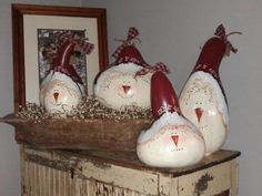 three snowmen sitting on top of a wooden shelf