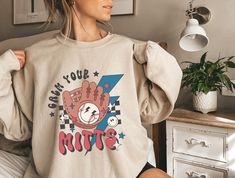 a woman wearing a sweatshirt that says own your mitts