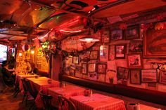 an empty restaurant with many tables and pictures on the wall