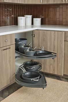 two pots and pans are in the corner of a cabinet