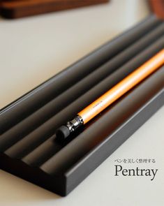 the pen tray is holding two pencils on it