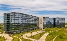 an aerial view of a large office building in the middle of a green park area