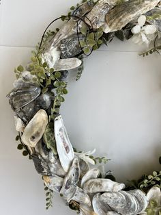 a wreath made out of seashells and greenery