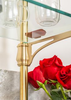 red roses sitting on top of a glass shelf