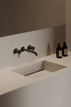 a bathroom sink with soap and lotion on the counter top next to it,