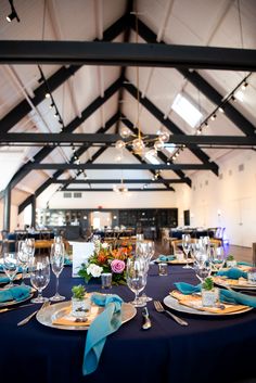 the table is set with blue linens and place settings