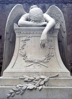 an angel statue sitting in the middle of a cement monument with leaves on it's sides