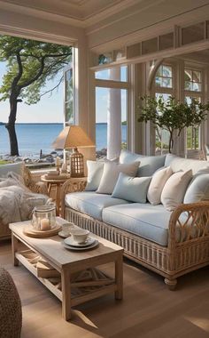 a living room filled with lots of furniture next to an ocean front window covered in wicker