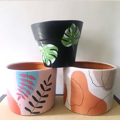 three plant pots with different designs on them