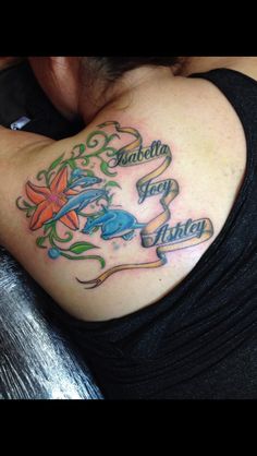 the back of a woman's shoulder with tattoos on her chest and name written in cursive writing