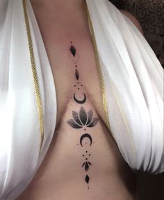 a woman's stomach with an intricate tattoo design on her belly and the moon behind it