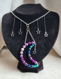 Dangly Moon and Stars Necklace. A gorgeous array of colourful glass pearl beads make up the large crescent moon at the front of this piece. Beautiful purples, lilacs, blues and turquoise tones are striking and are flanked by dangly stars. An unusual and unique, quirky piece. Please note my usual posting day is Thursday (Although this may change, posting will be confirmed at time of purchase). There are also still mail delivery delays . Please allow extra days for arrival. Necklace length is appr Moon And Stars Necklace, Moon Drop, Stars Necklace, Necklace Moon, Hippie Necklace, Jewellery Uk, Moon And Stars, Beautiful Rainbow, Star Charms