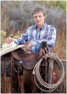 a young man sitting on top of a brown horse next to a rope and saddle