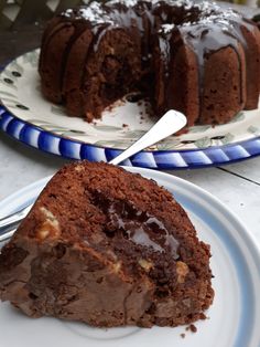 there is a piece of chocolate cake on the plate next to the bundt cake