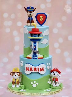 a three tiered cake decorated with dogs and firetrucks on the top