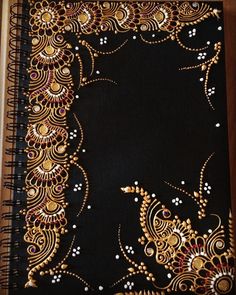 a black notebook with gold and white designs on it