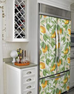 a kitchen with white cabinets and an orange wallpaper on the side of the refrigerator