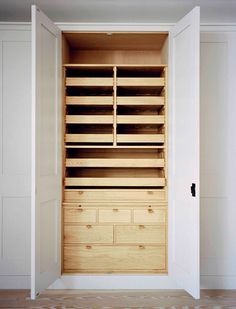 an empty closet with wooden drawers and white walls