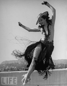 a woman in a dress and hat is dancing