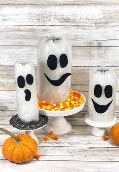 some white candles with black faces and candy corn