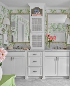 a bathroom with green and white wallpaper, two sinks and mirrors on the wall