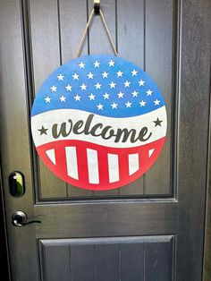 a welcome sign hanging on the front door of a house that is decorated with stars and stripes