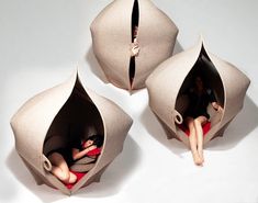 three people are sitting in an umbrella shaped object that looks like a woman laying on the floor