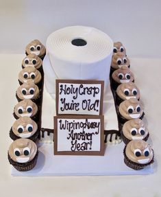 a roll of toilet paper sitting on top of a table next to cupcakes