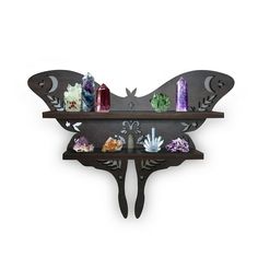 a metal butterfly shelf with candles and other items on it's back wall mounted