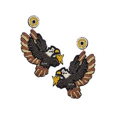 two black and white eagle earrings with yellow eyes on them, one has an eyeball in the middle