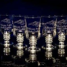 six glass goblets are lined up on a black surface with the words, american pub and fish co