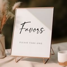 a sign that says favors on it next to a vase with some flowers in it