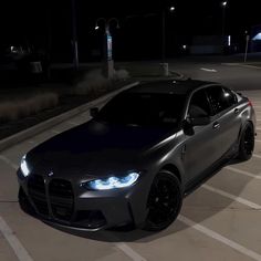 a black car parked in a parking lot at night