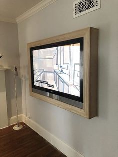 a flat screen tv mounted to the side of a wall in an empty living room