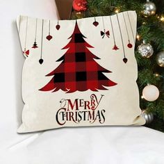 a christmas tree pillow sitting on top of a bed