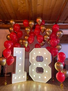 the number eight is surrounded by balloons and streamers in gold, red, and white