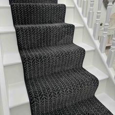 black carpeted stairs with white railings