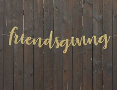 a string that says,'friends giving'hanging on a wooden fence with the word