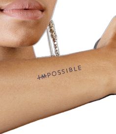 a woman's arm with the word impossible written on it