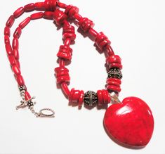 "Red heart pendant on red bamboo coral bead necklace, with sterling silver Bali beads, and sterling toggle closure. Bright true red riverstone heart pendant is the centerpiece on the bright red coral bead necklace. Two large solid sterling Bali beads are featured on each side of the pendant. The red heart pendant with sterling bail meaures 1 3/4\" from the top of the bail to the tip of the heart, and it is 1 3/8\" wide. The red coral necklace is 19\" long. Show someone you love that your heart r Traditional Red Heart-shaped Jewelry, Red Heart Pendant, Red Bamboo, Red Coral Earrings, Red Coral Necklace, Coral Beads Necklace, Bamboo Coral, Coral Earrings, Coral Necklace