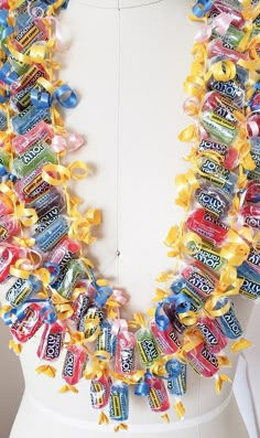 a white mannequin with candy bars on it's neck and yellow ribbons