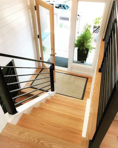 an open door leading to a balcony with wooden floors and black railings on either side